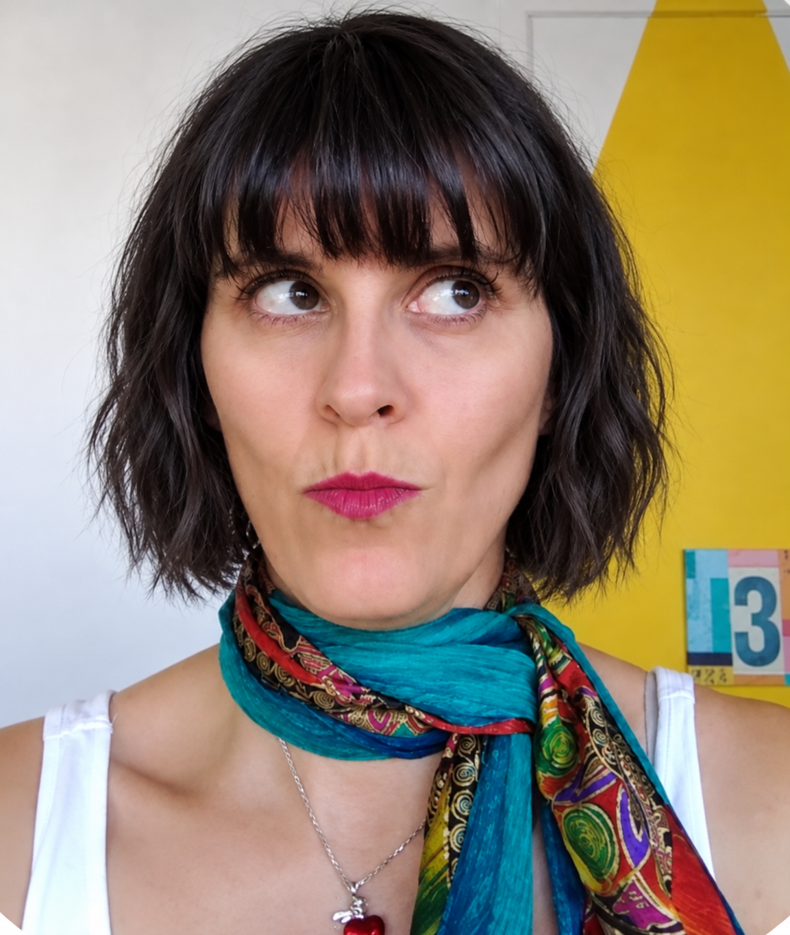 Holly in a colourful scarf, rolling her eyes with a playful pout